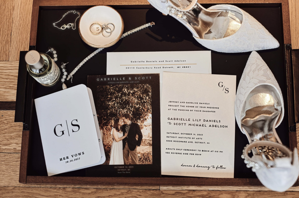 Flat lay details with wedding rings and invitation suite at a Michigan wedding. Photo taken by Erika Black Photography